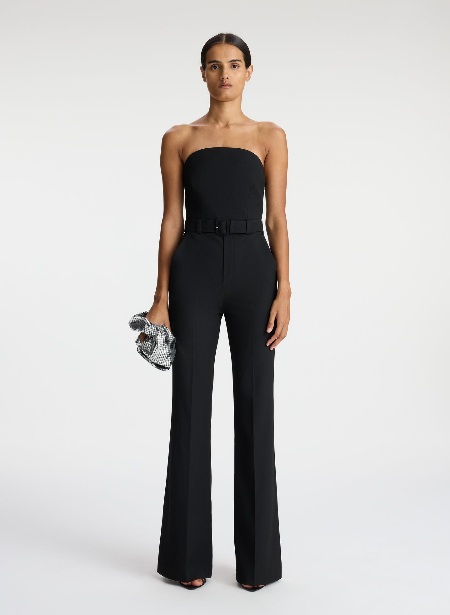 front view of woman wearing black strapless jumpsuit