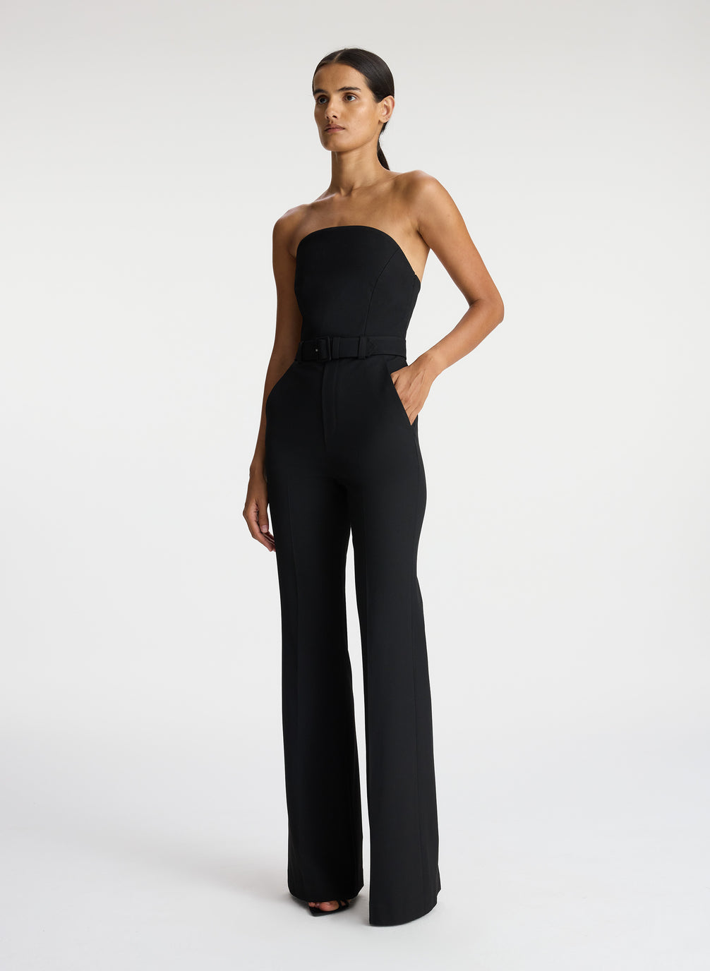 side view of woman wearing black strapless jumpsuit