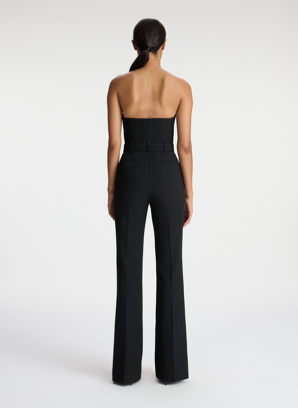 back view of woman wearing black strapless jumpsuit