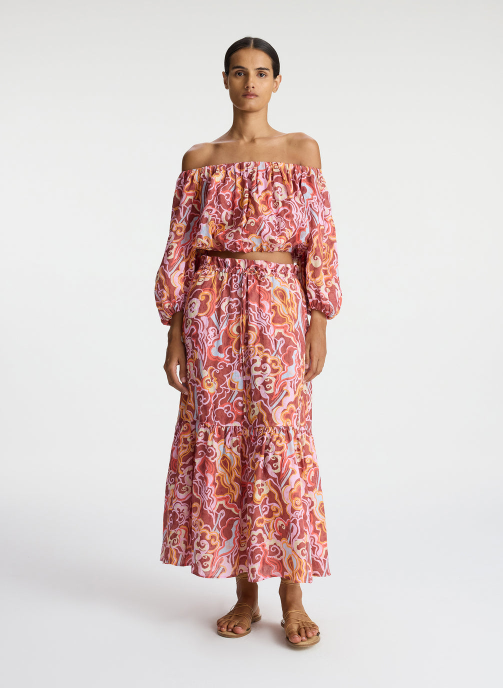 front view of woman wearing off shoulder printed linen top and matching midi skirt 