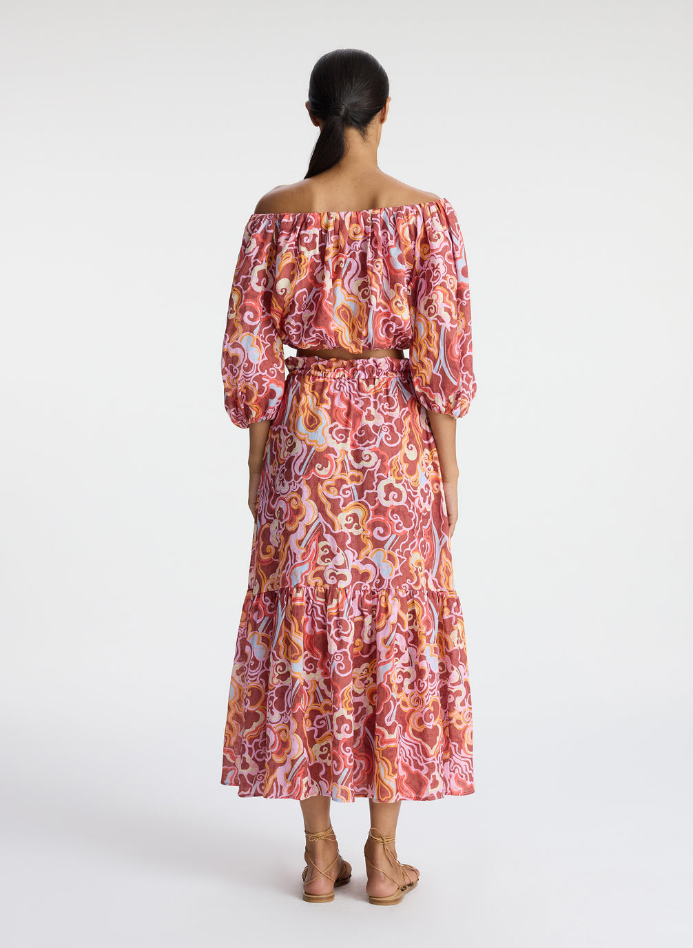 back view of woman wearing off shoulder printed linen top and matching midi skirt