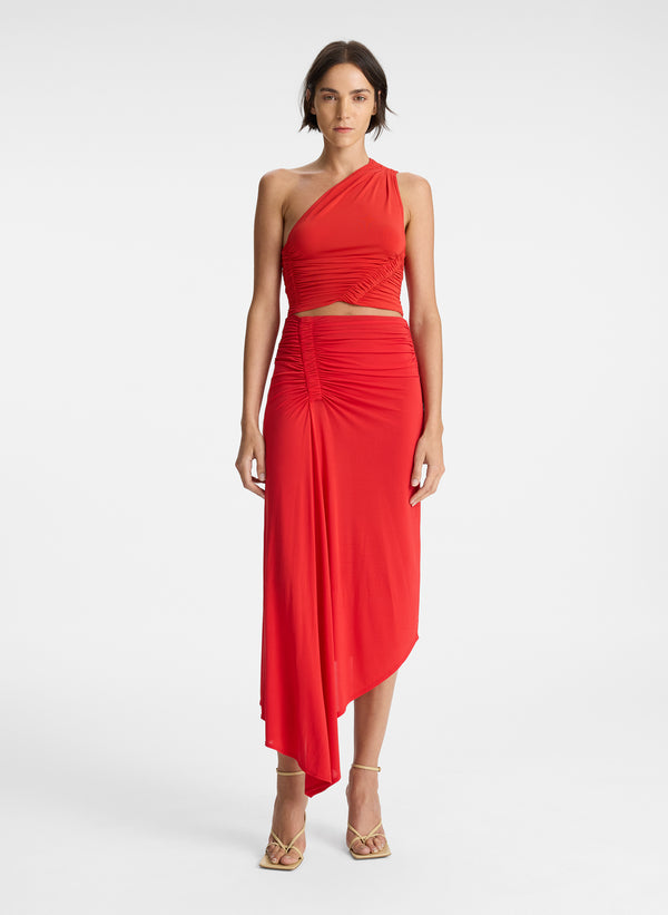 front view of woman wearing red one shoulder tank top and red ruched midi skirt