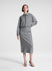 woman wearing black and white plaid gingham jacket and matching skirt