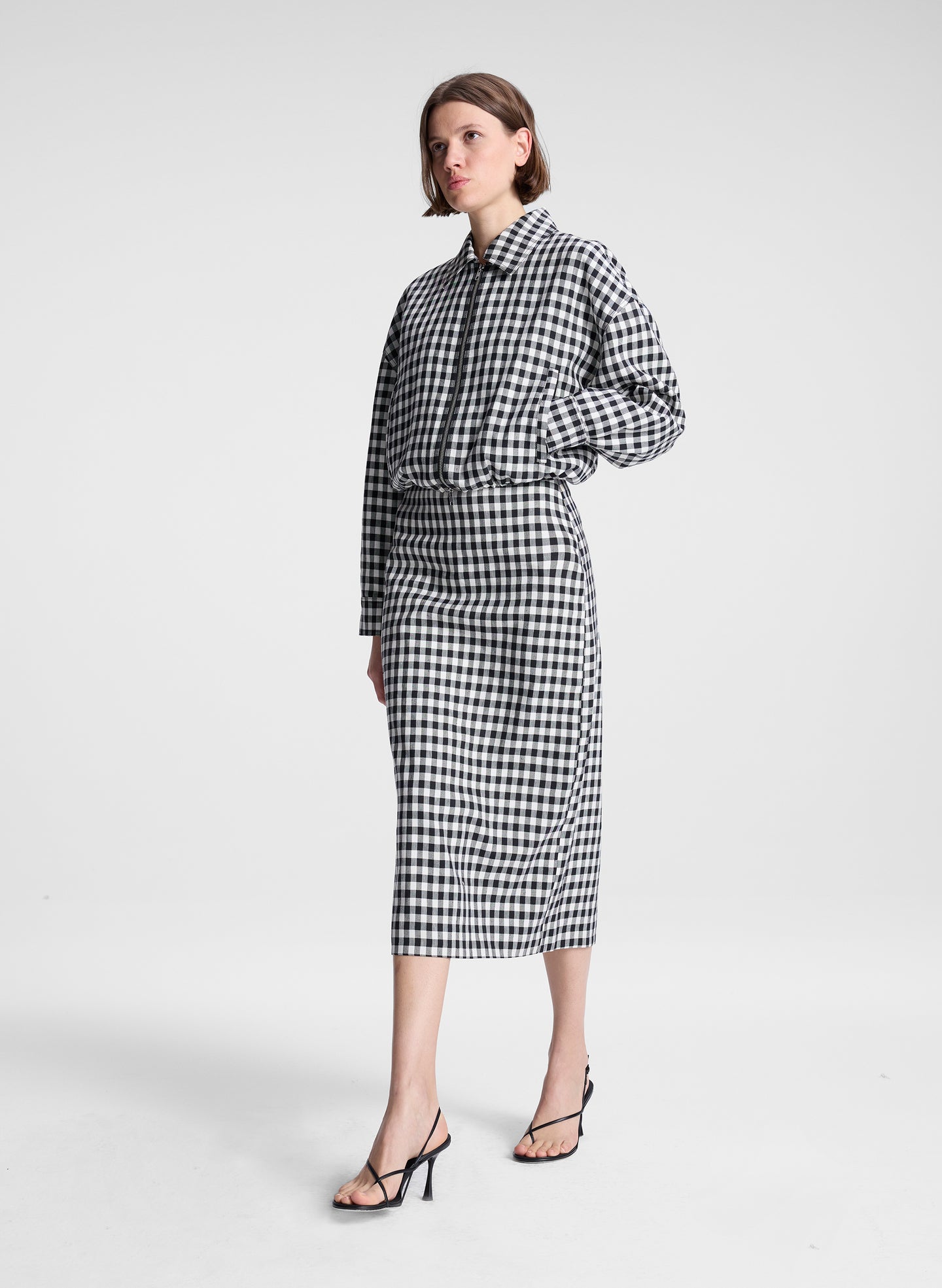 woman wearing black and white plaid gingham jacket and matching skirt