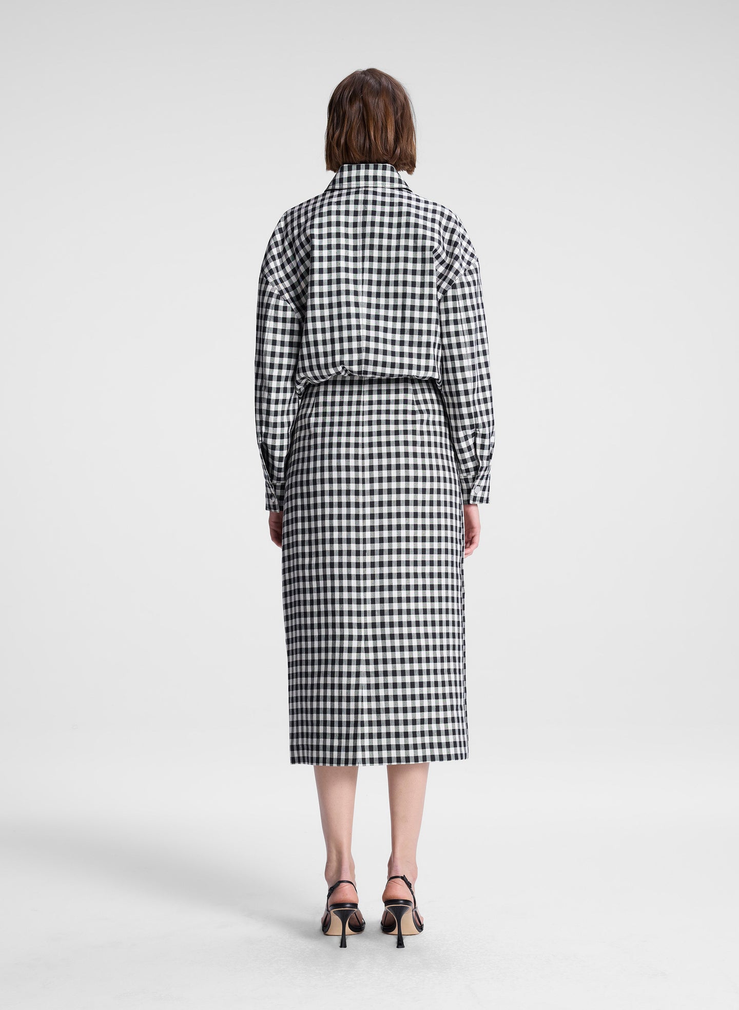 woman wearing black and white plaid gingham jacket and matching skirt