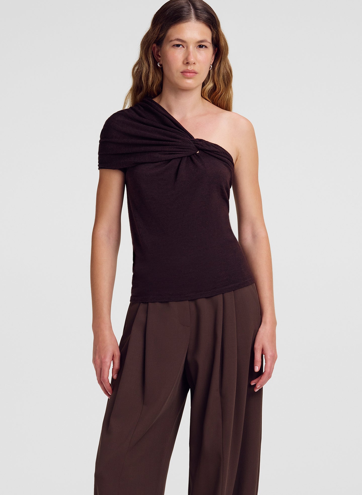 woman wearing brown one shoulder merino top and brown pants