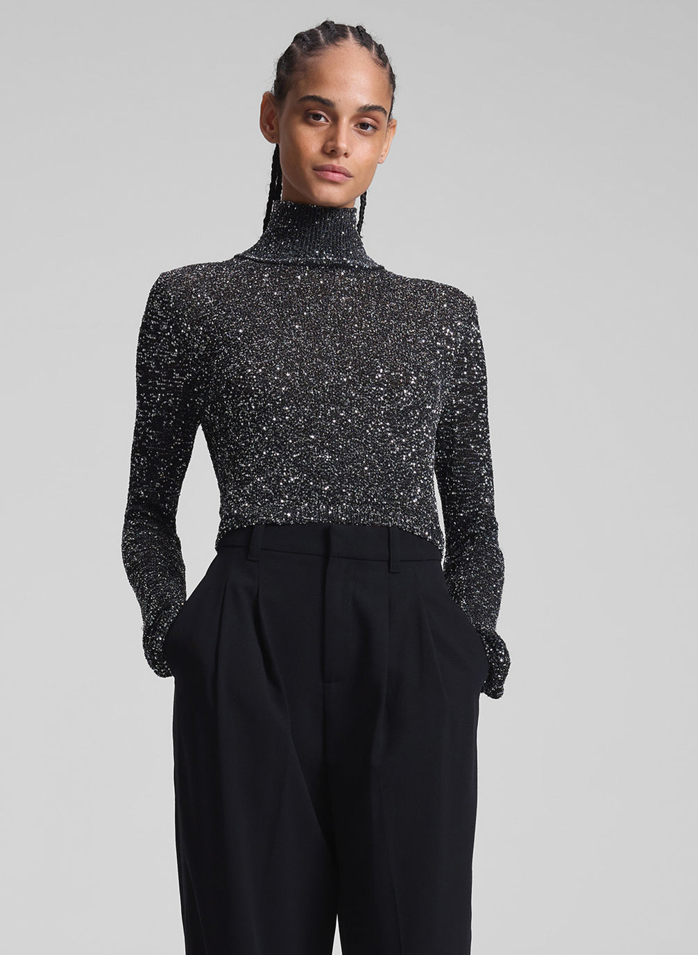 woman wearing sequined turtleneck and black pants