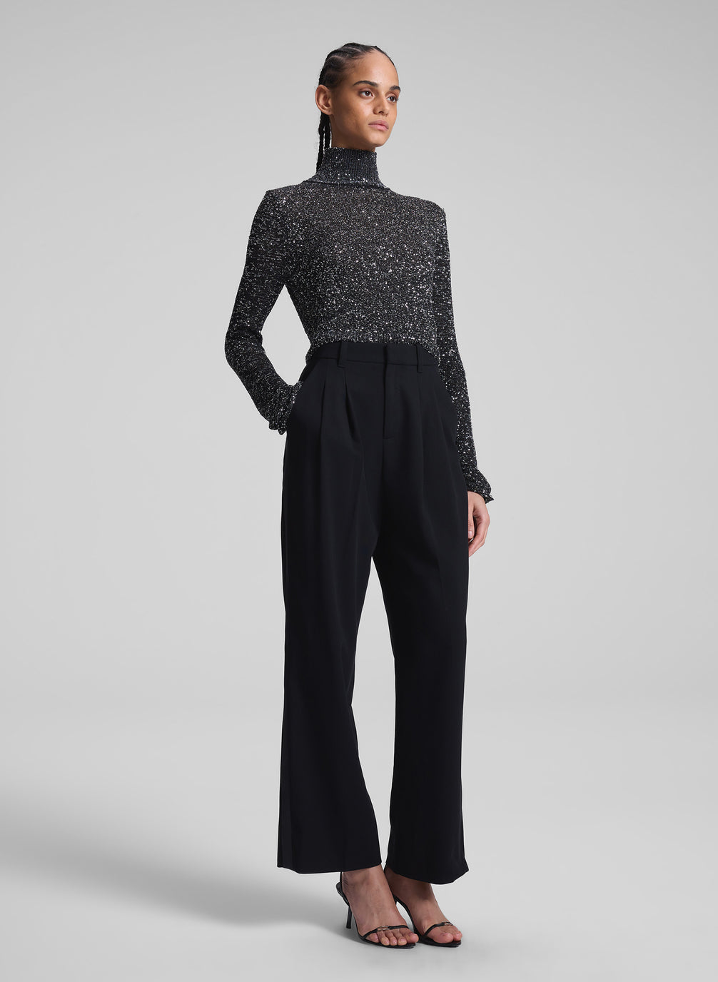 woman wearing sequined turtleneck and black pants