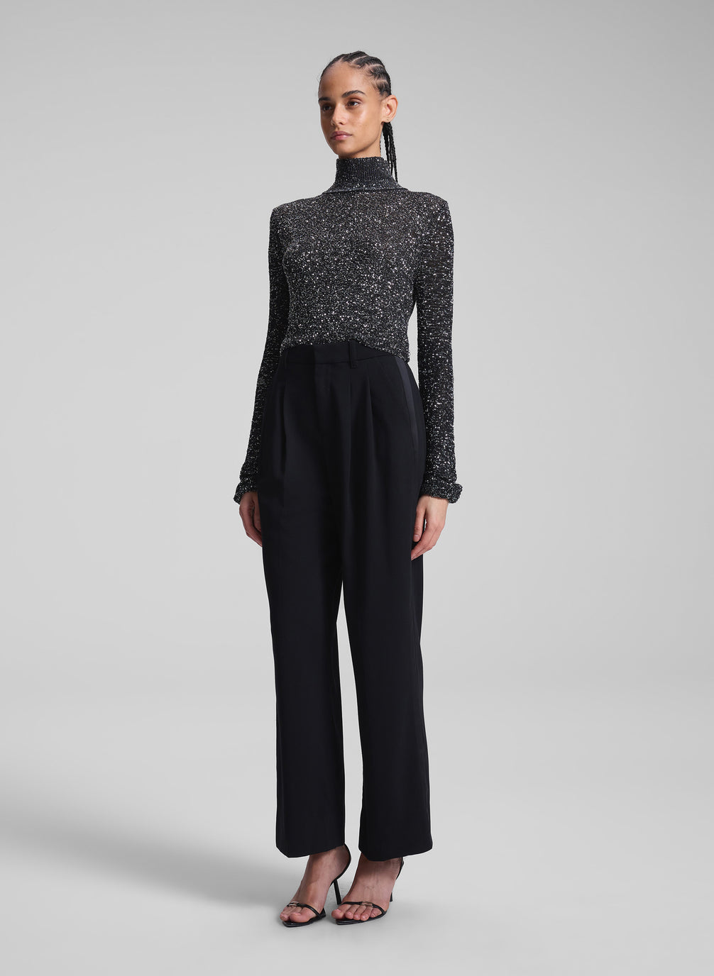 woman wearing sequined turtleneck and black pants