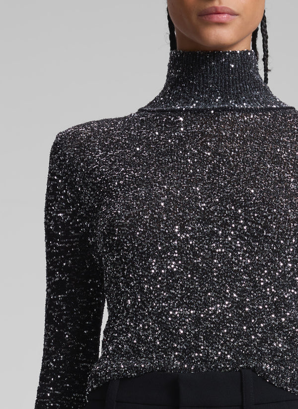 woman wearing sequined turtleneck and black pants