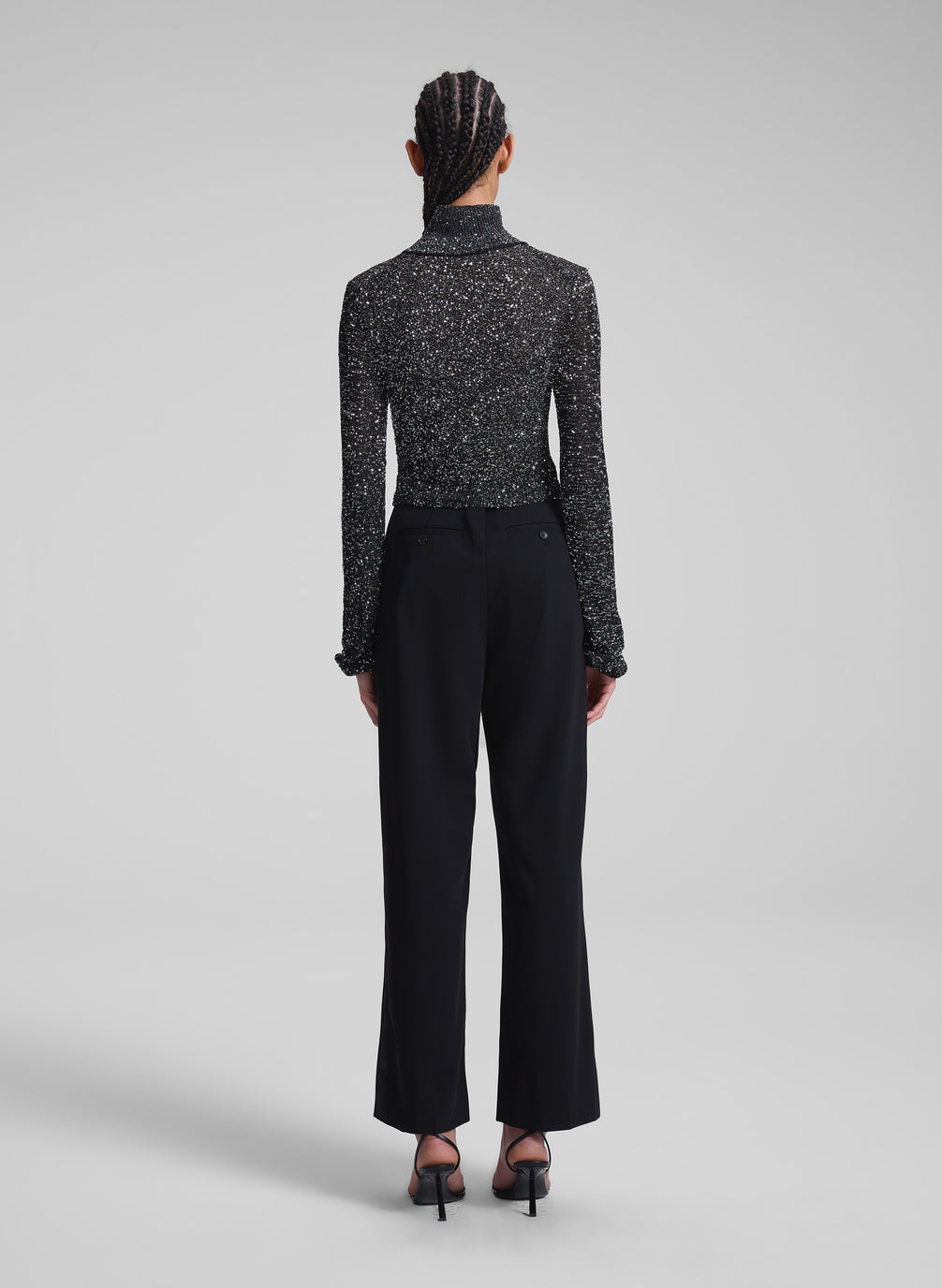 woman wearing sequined turtleneck and black pants