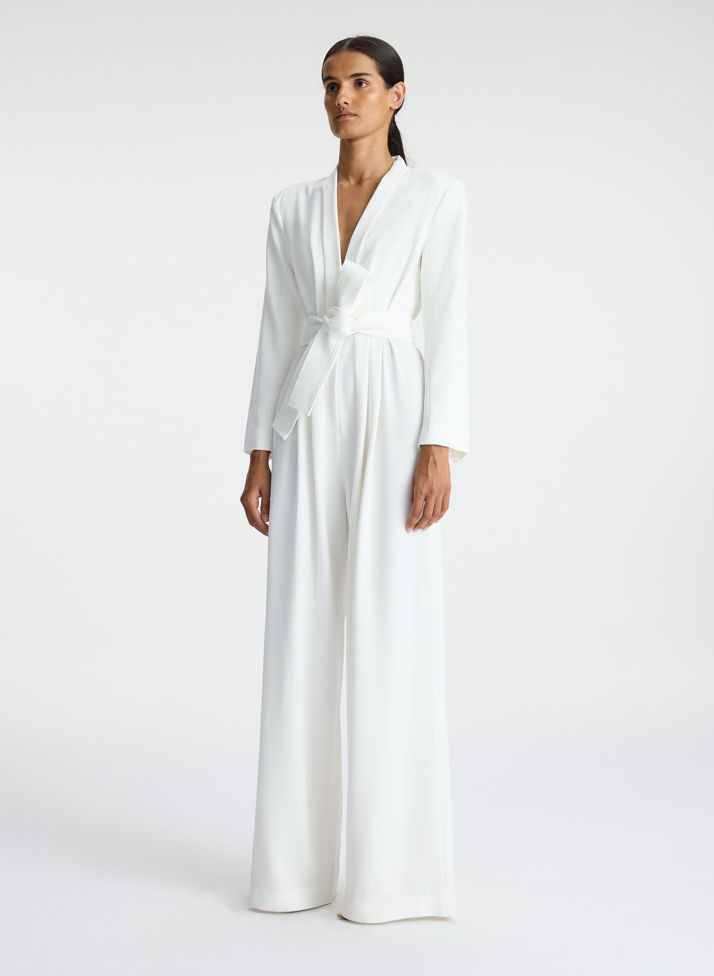 side view of woman wearing white long sleeve jumpsuit