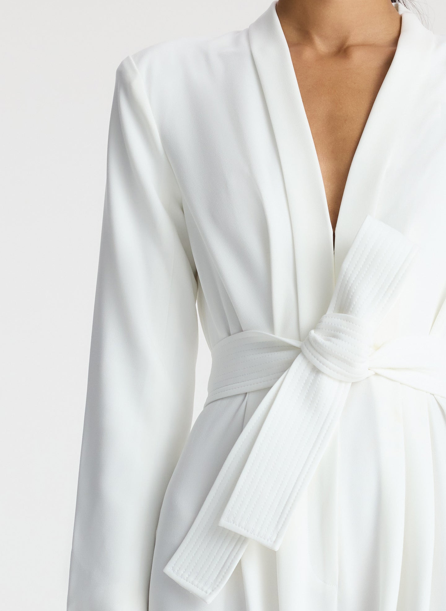 detail view of woman wearing white long sleeve jumpsuit