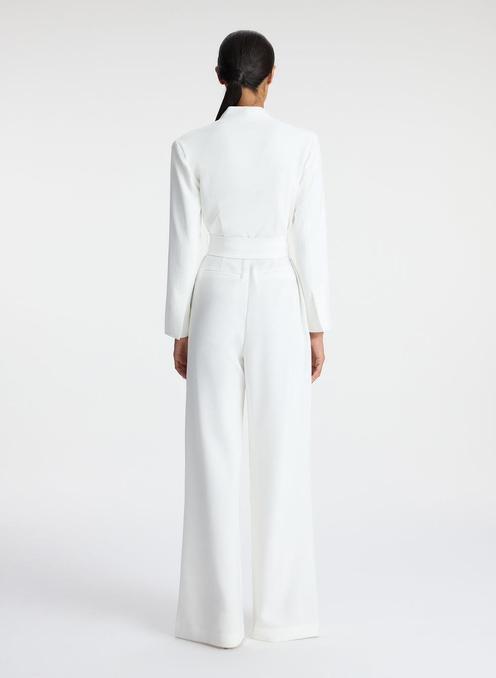 back view of woman wearing white long sleeve jumpsuit