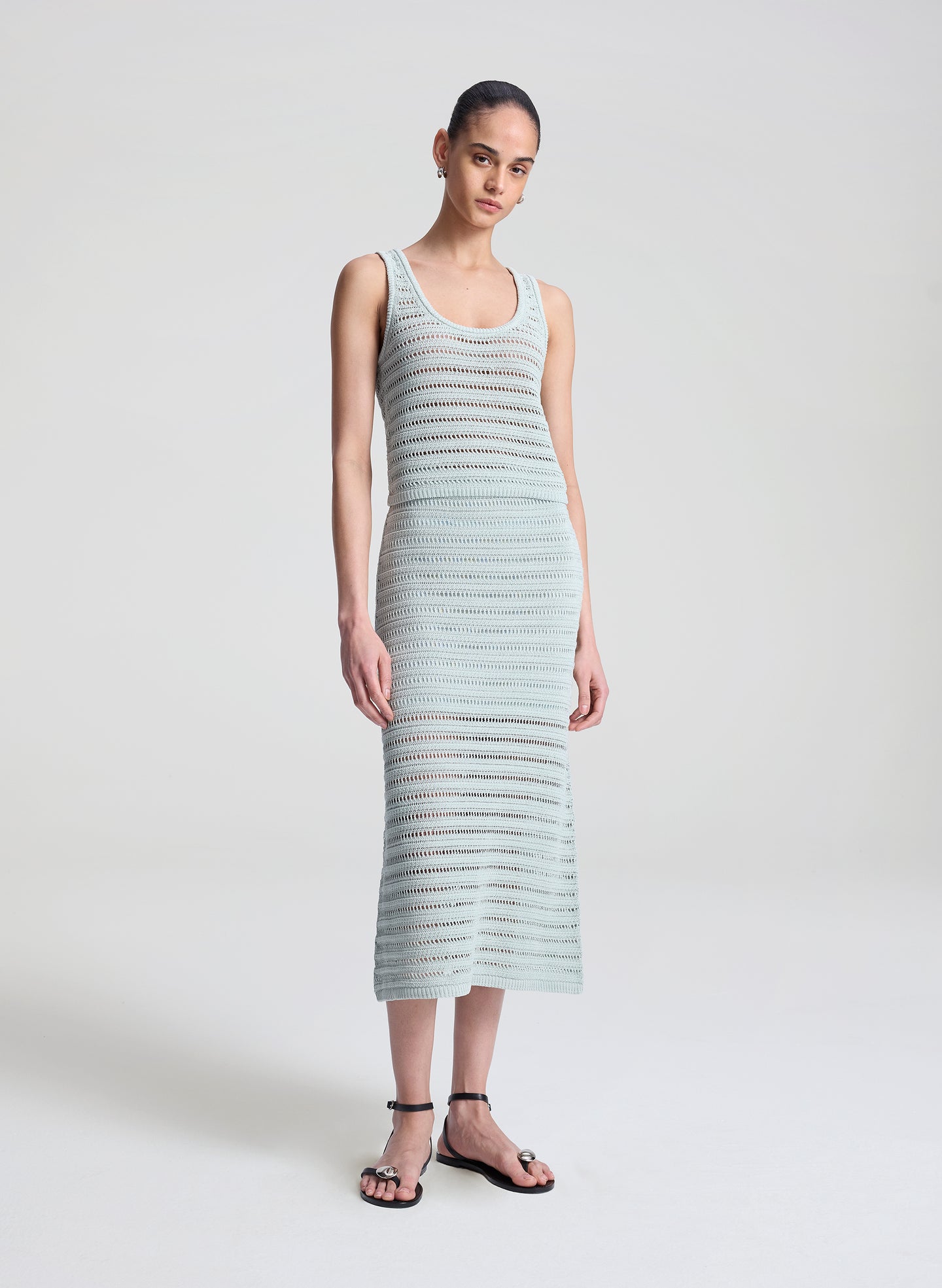 woman wearing light blue crochet tank and skirt set