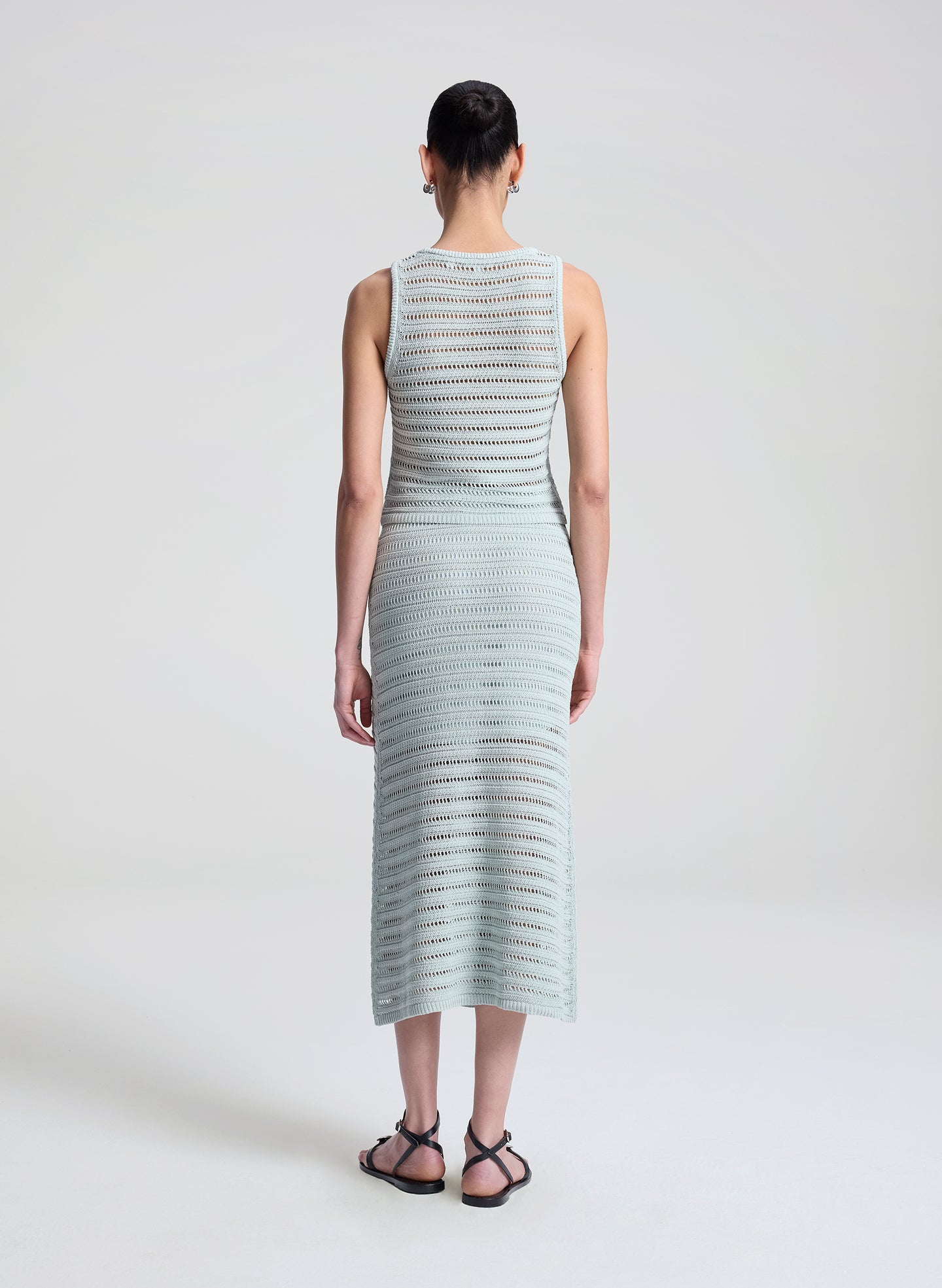 woman wearing light blue crochet tank and skirt set