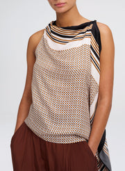 Woman wearing a sleeveless patterned top with a plain background