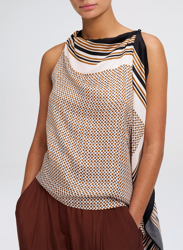 Woman wearing a sleeveless patterned top with a plain background