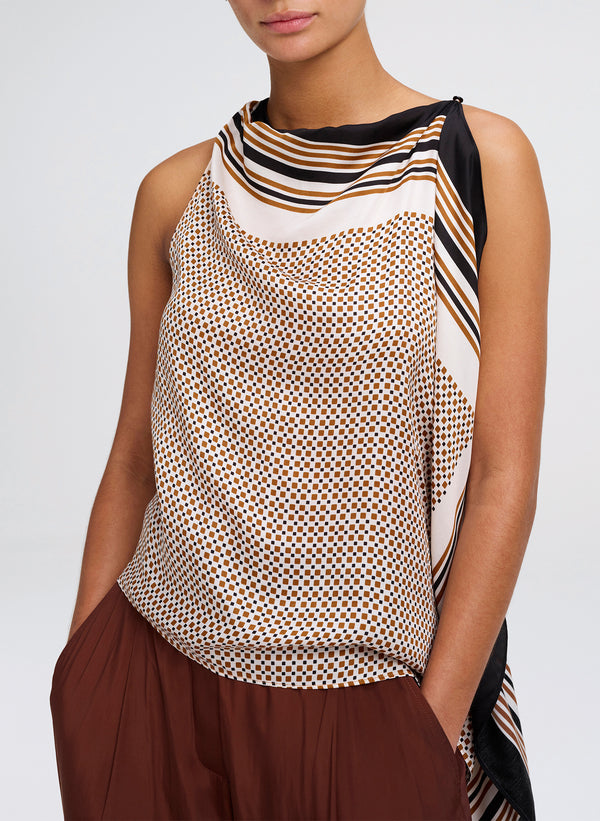 A sleeveless draped top with a beige, brown, and black geometric pattern and striped border details, shown on a model against a light gray background.