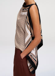 A sleeveless draped top with a mixed geometric print in beige, brown, black, and white, shown on a model from the side against a light gray background.