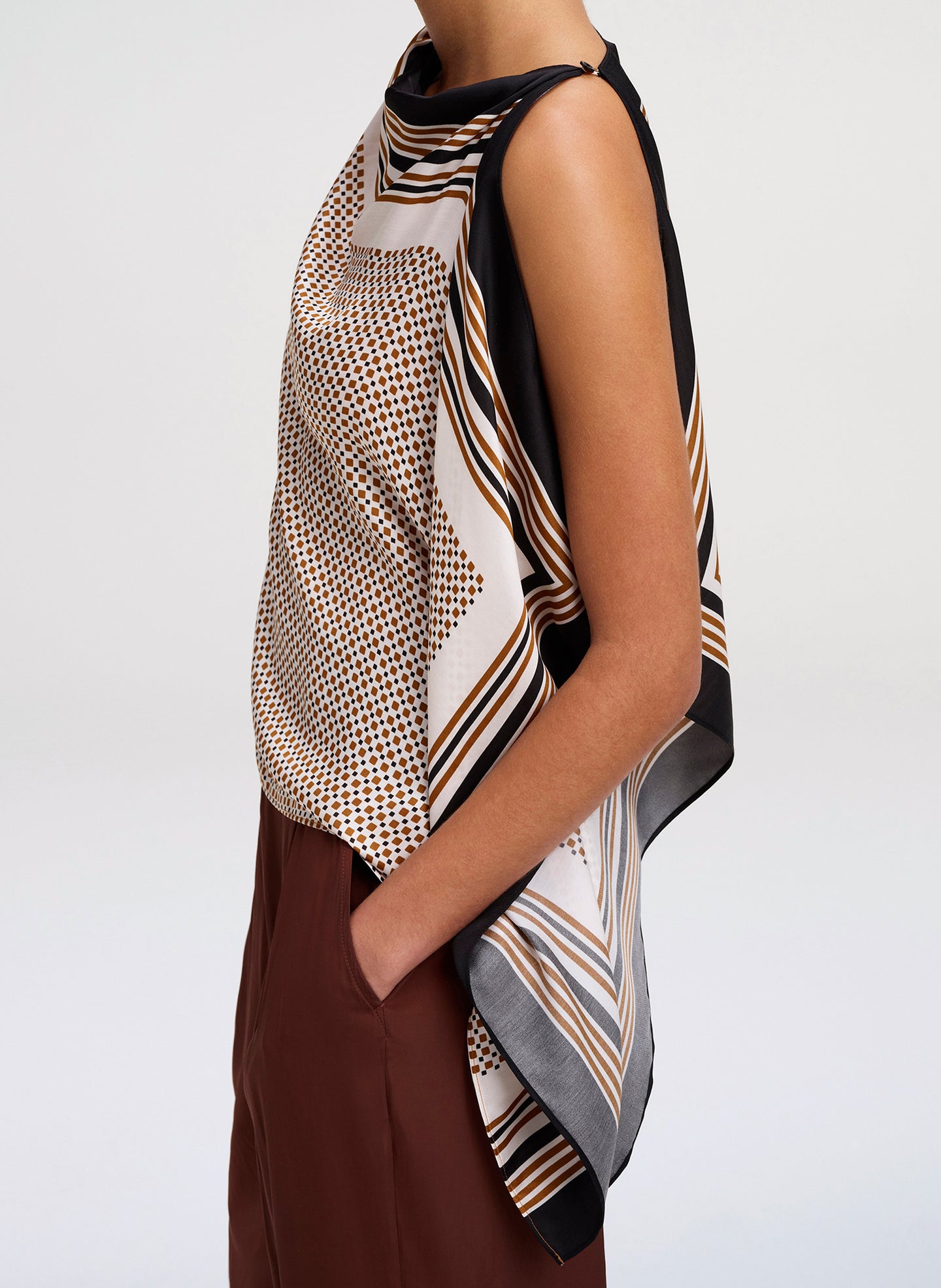 Woman wearing a patterned scarf on a plain background