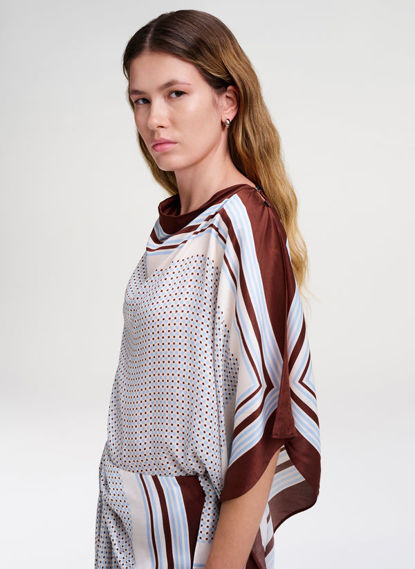 Woman wearing a patterned scarf top on a white background