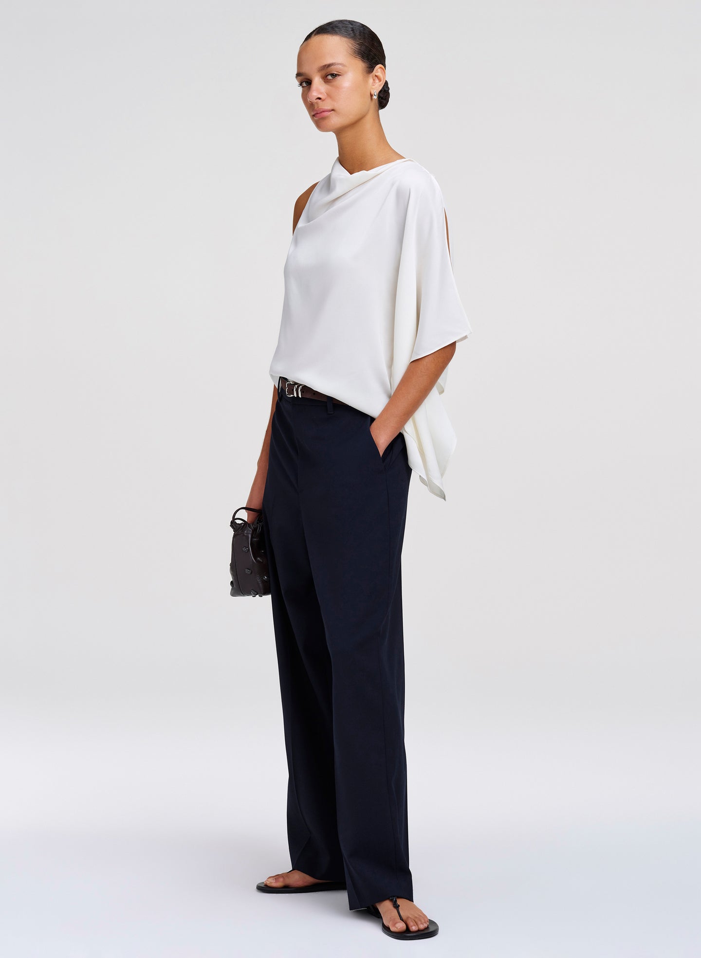 woman wearing white draped blouse and dark blue pants