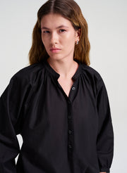 Woman wearing a black blouse against a white background