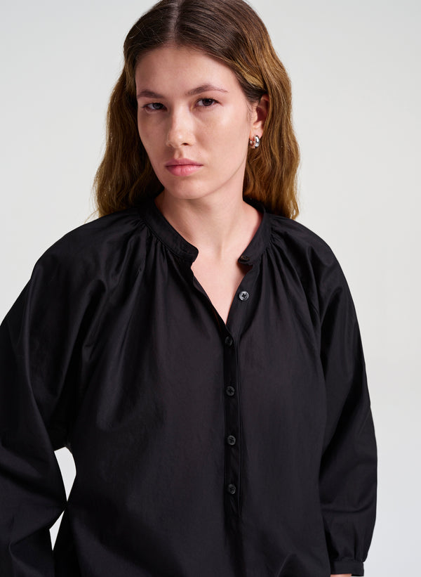Woman wearing a black blouse against a white background