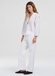 Woman wearing a white outfit with a plain background