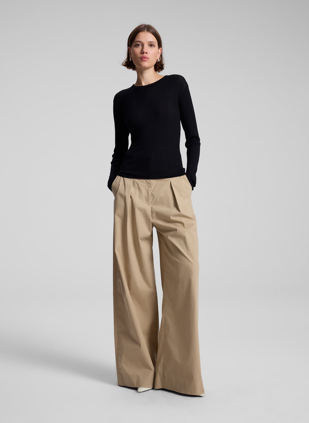 woman wearing black long sleeve top and tan wide leg pant