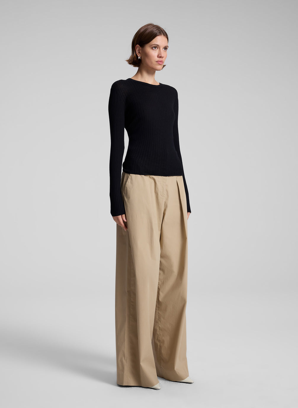 woman wearing black long sleeve top and tan wide leg pant