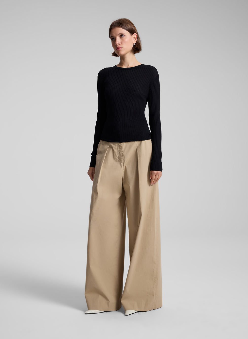 woman wearing black long sleeve top and tan wide leg pant