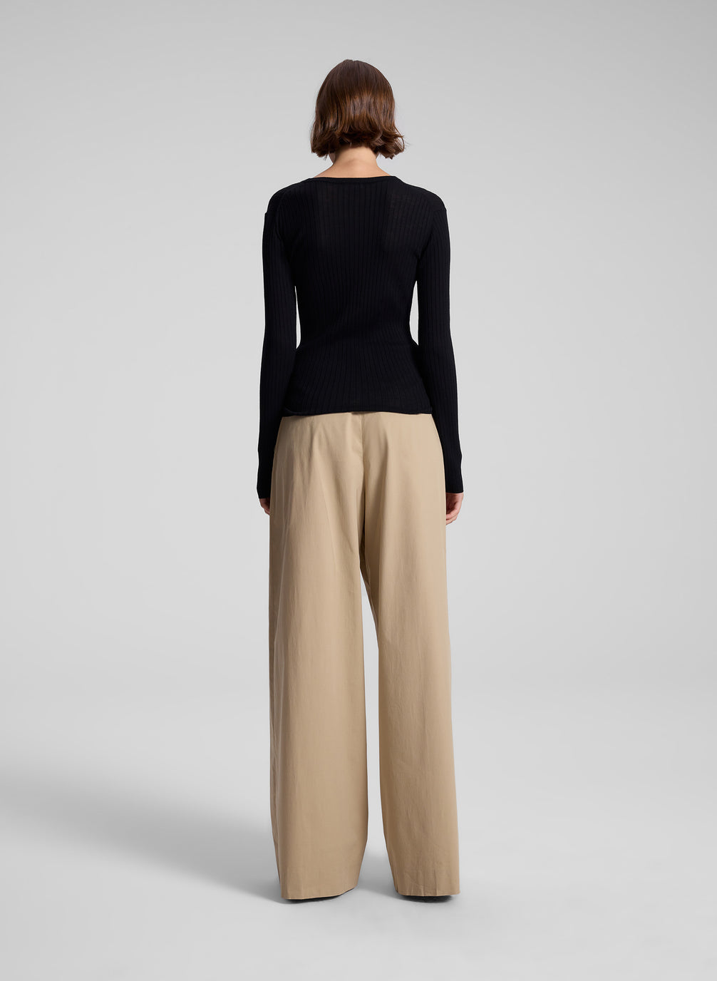 woman wearing black long sleeve top and tan wide leg pant