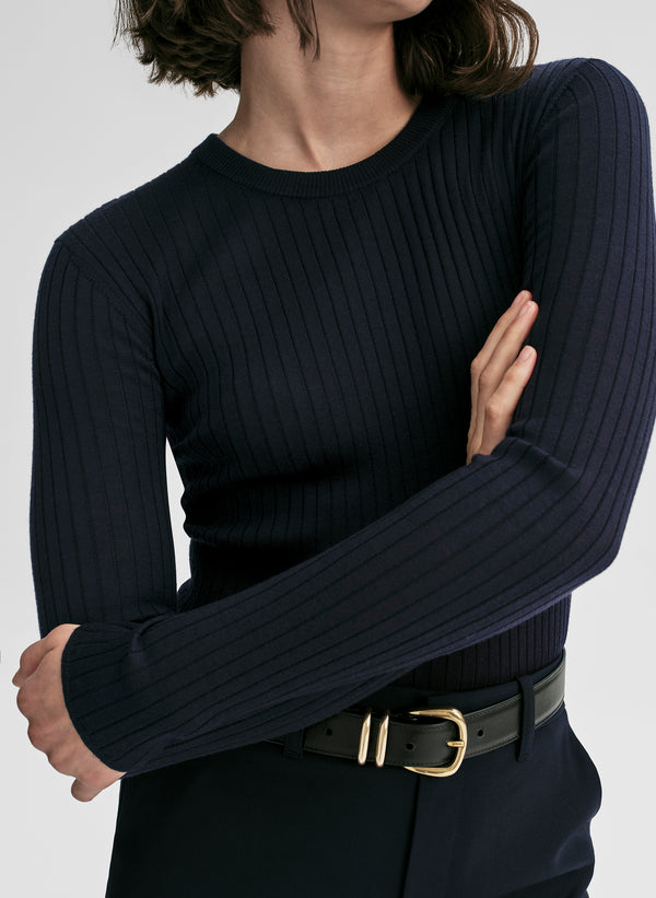 woman wearing a navy blue ribbed sweater and navy blue pants