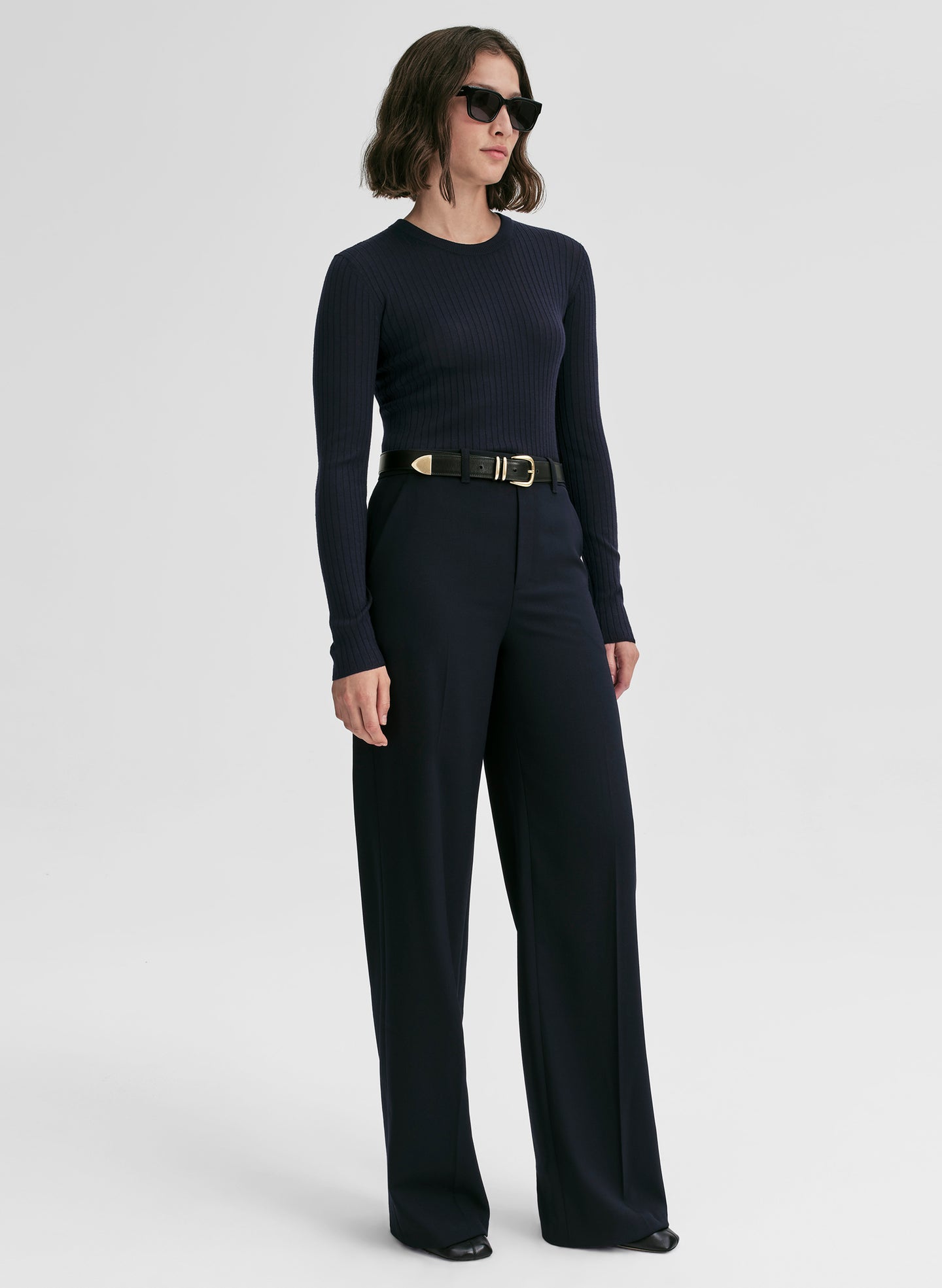 woman wearing a navy blue ribbed sweater and navy blue pants
