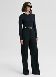 woman wearing a navy blue ribbed sweater and navy blue pants
