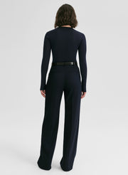 woman wearing a navy blue ribbed sweater and navy blue pants