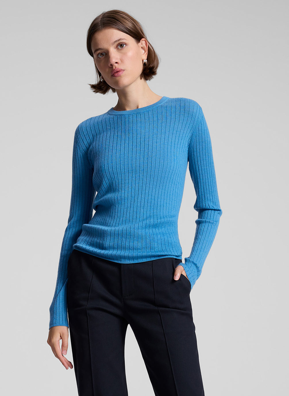 woman wearing blue knit top and black pants