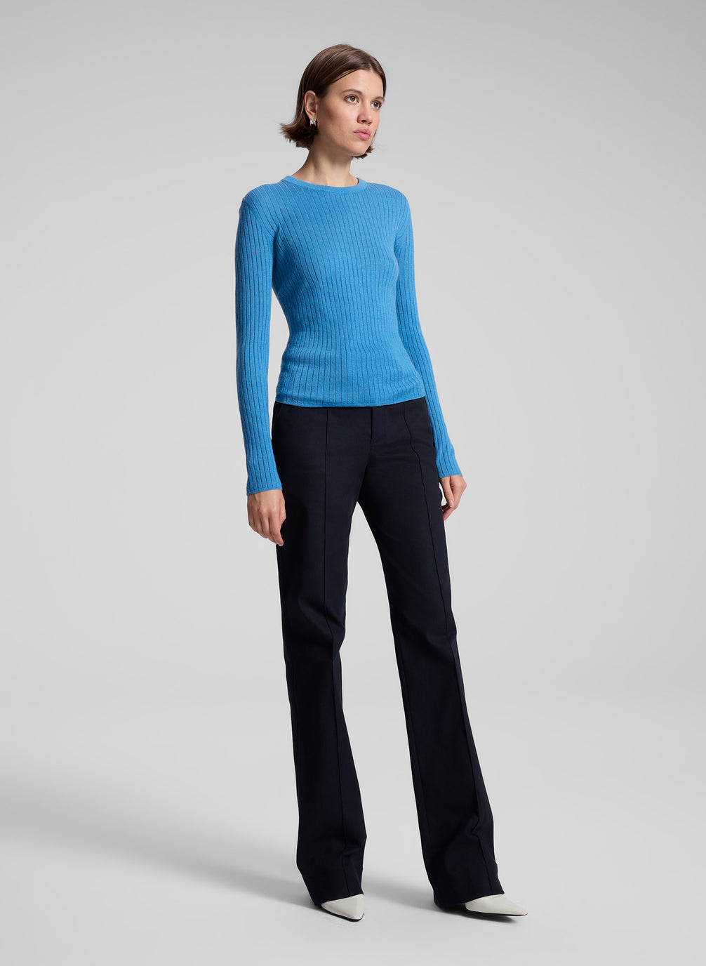 woman wearing blue knit top and black pants