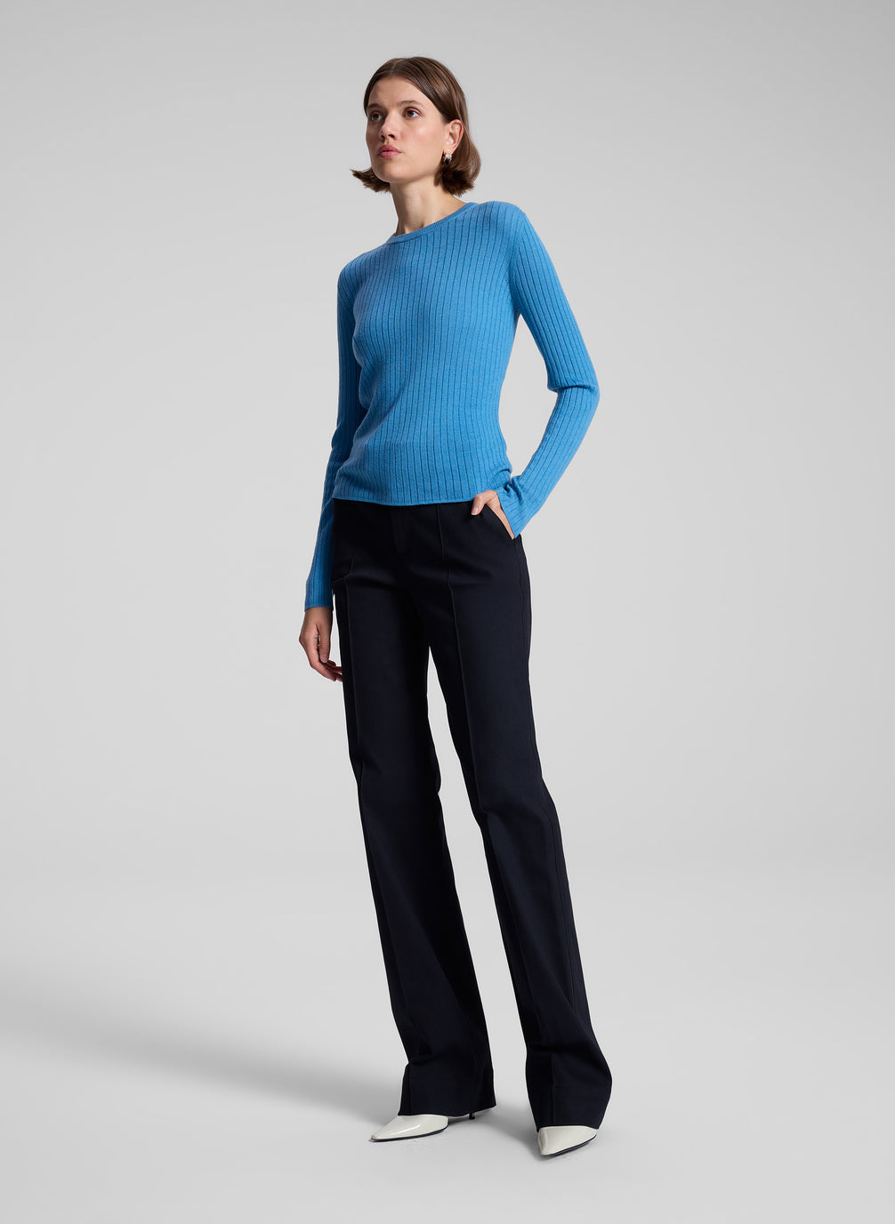 woman wearing blue knit top and black pants