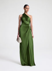 Woman wearing a green one-shoulder pleated dress on a white background