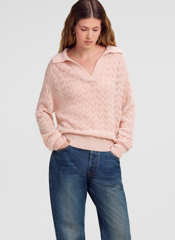 woman wearing pink collared sweater and blue denim jeans