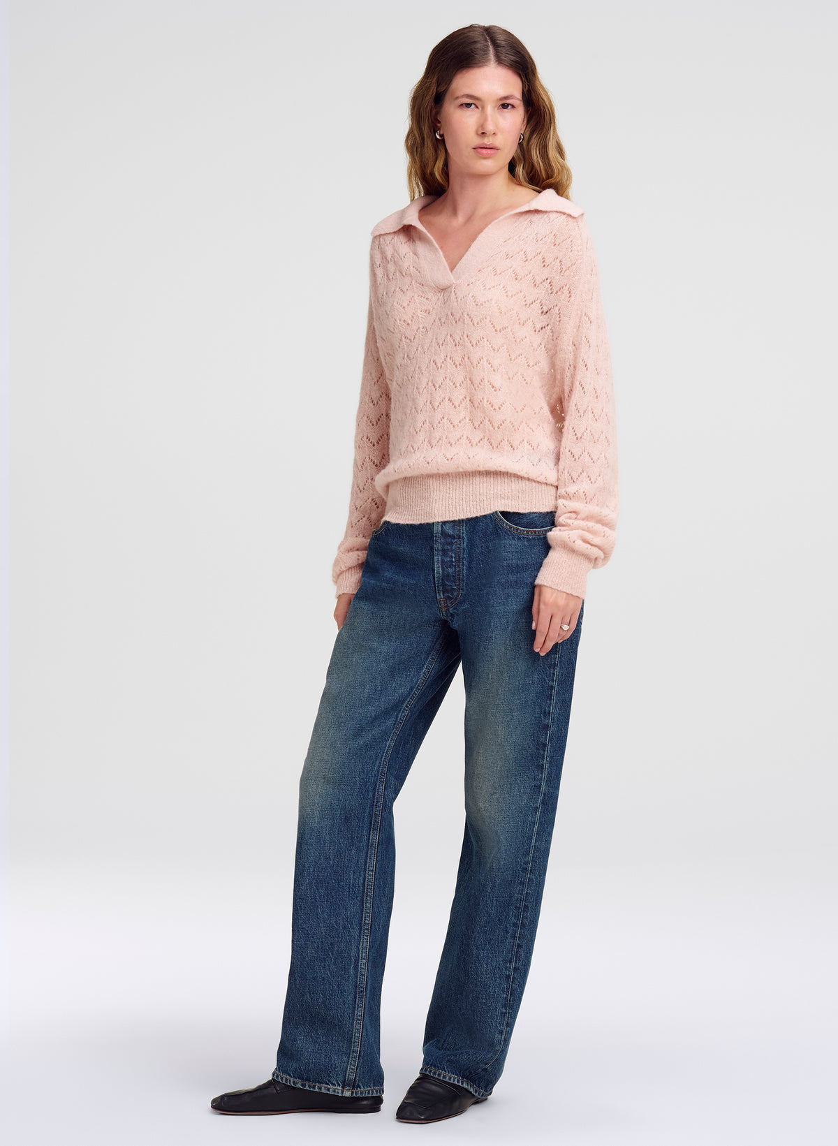 woman in pink collared sweater and blue denim jeans