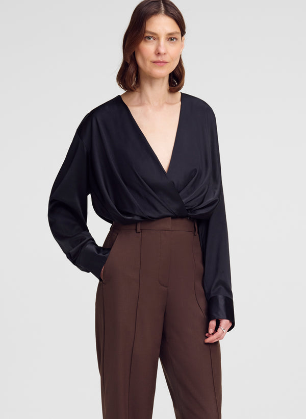 woman wearing black silk top and brown pants