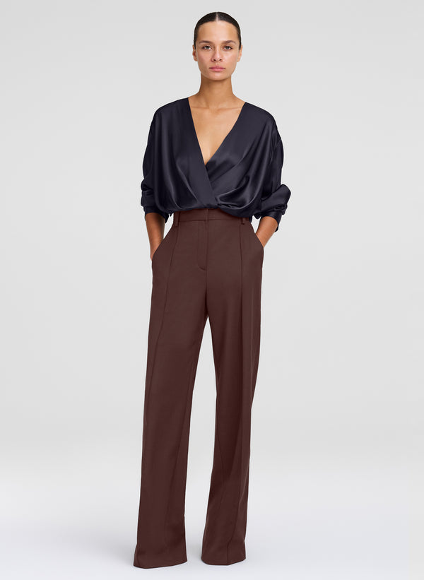 woman in black silk top and brown pants