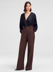 woman in black silk top and brown trouser pants