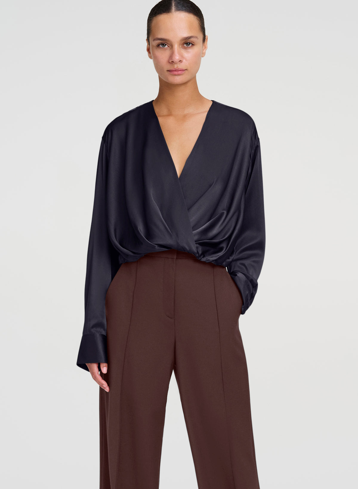 woman wearing black silk top and brown trouser pants