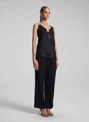 woman wearing black lace camisole and black pants