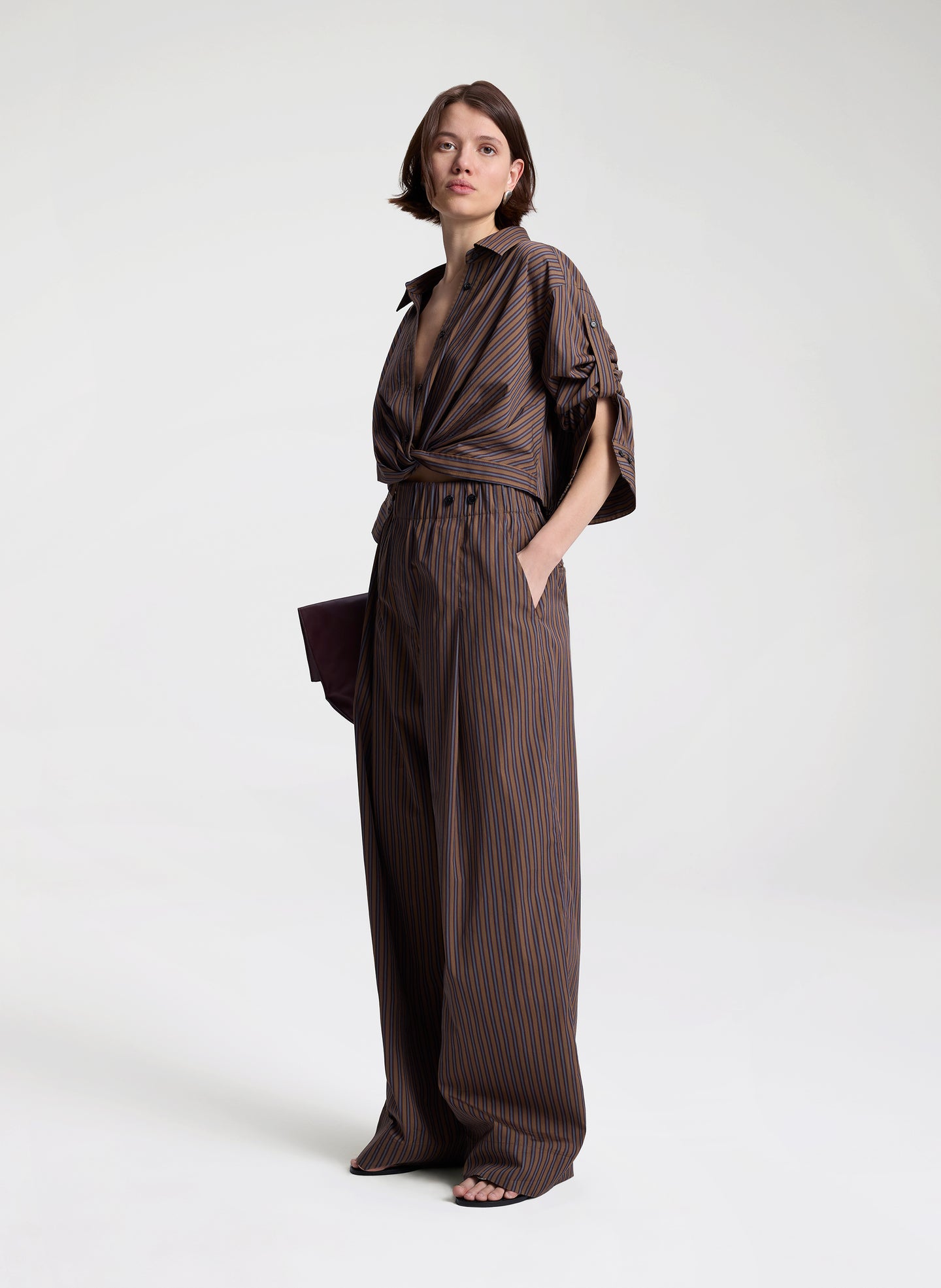 woman wearing brown button down shirt and matching set brown striped pants